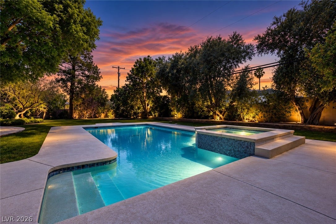 2001 Silver Avenue, Las Vegas, NV 89102 Mature trees frame a concrete patio surrounding a sparkling pool and spa at twilight.