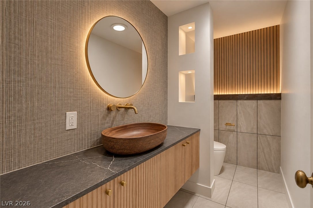 2001 Silver Avenue, Las Vegas, NV 89102 Textured wall finishes and warm accent lighting elevate this modern powder room design.