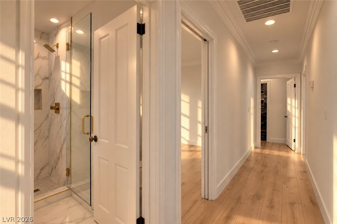 2001 Silver Avenue, Las Vegas, NV 89102 Gleaming hardwood floors and classic crown molding line this sunlit residential hallway.