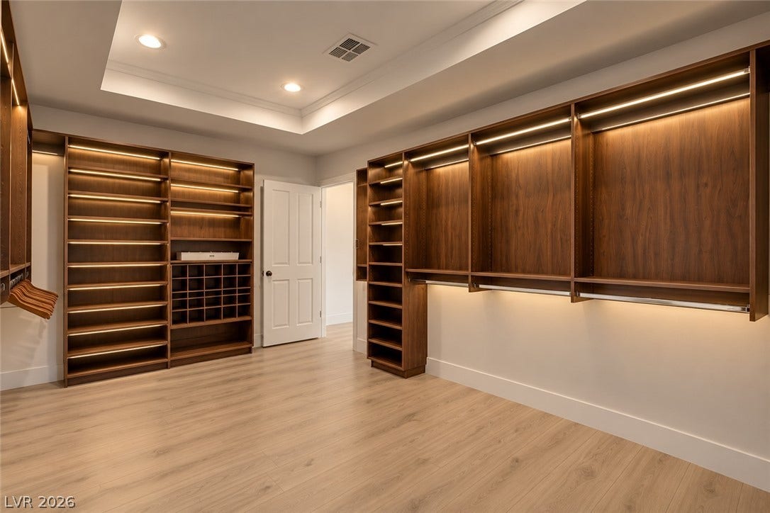 2001 Silver Avenue, Las Vegas, NV 89102 Custom wood shelving and integrated lighting define this organized walk-in closet space.