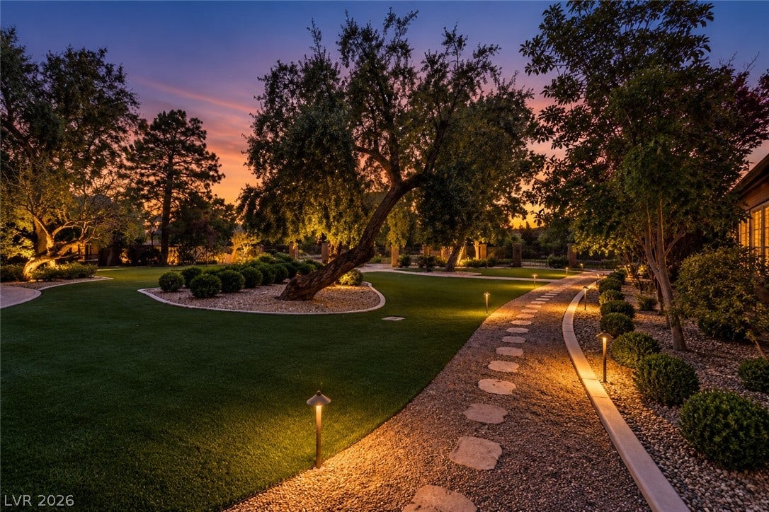 2001 Silver Avenue, Las Vegas, NV 89102 A winding stone pathway meanders through meticulously manicured lawns and mature trees highlighted by landscape lighting.
