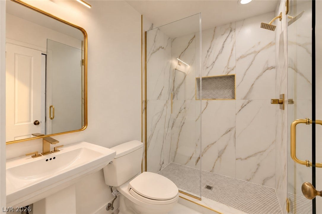 2001 Silver Avenue, Las Vegas, NV 89102 Elegant gold accents complement the marble-tiled walk-in shower and clean pedestal sink.