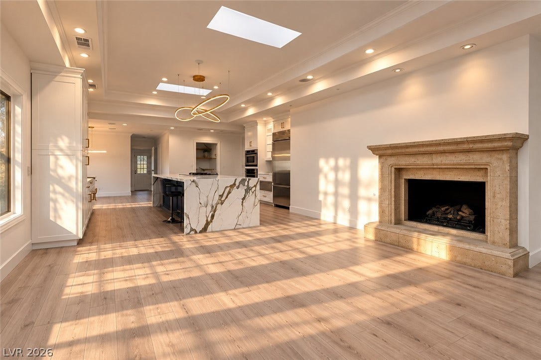 2001 Silver Avenue, Las Vegas, NV 89102 An open living area features a grand stone fireplace and wide-plank wood flooring.
