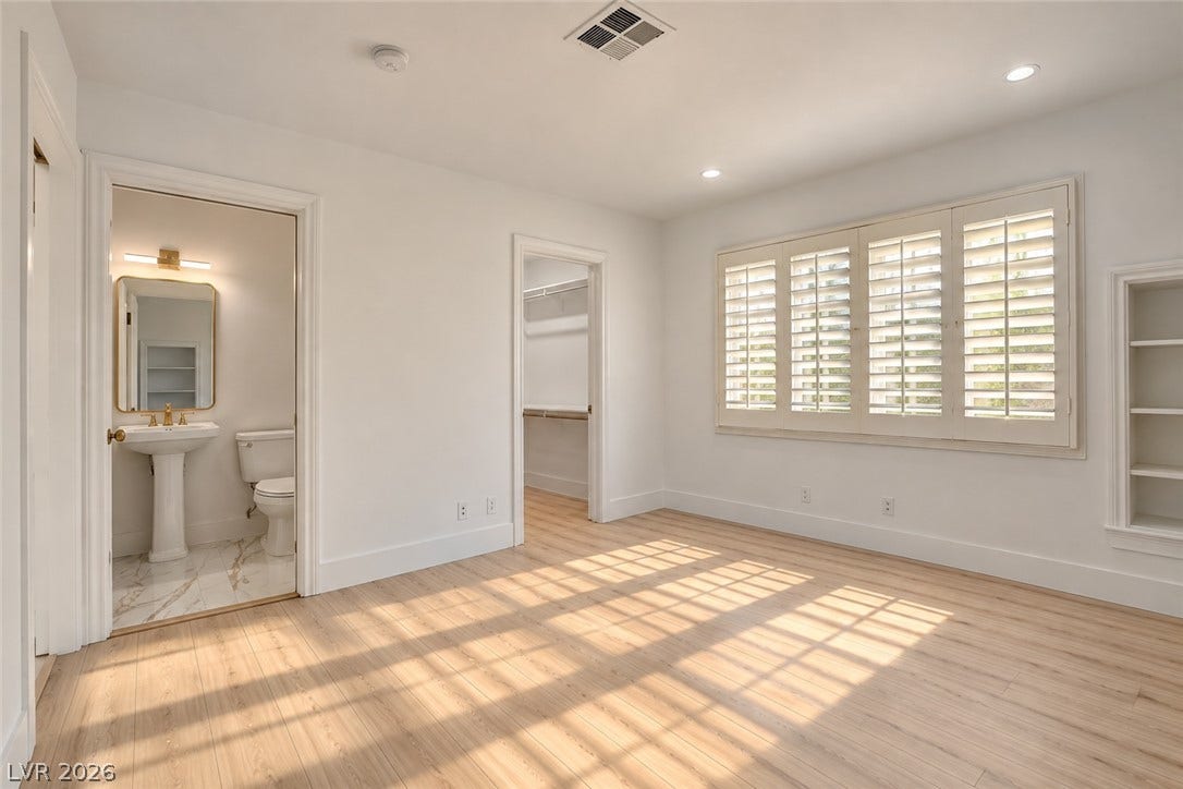 2001 Silver Avenue, Las Vegas, NV 89102 Sunlight streams across the wood floors of this spacious bedroom with an en suite bath.