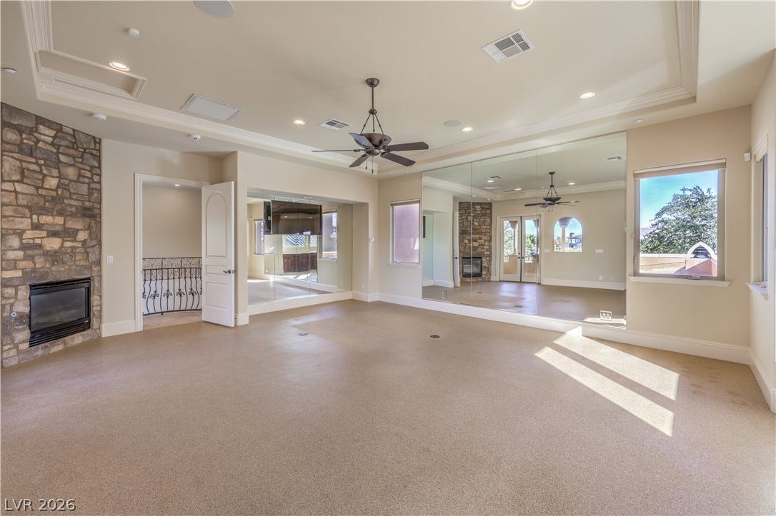 16 Anthem Pointe Court, Henderson, NV 89052 Natural stone masonry frames a warm fireplace in this light-filled room featuring crown molding.