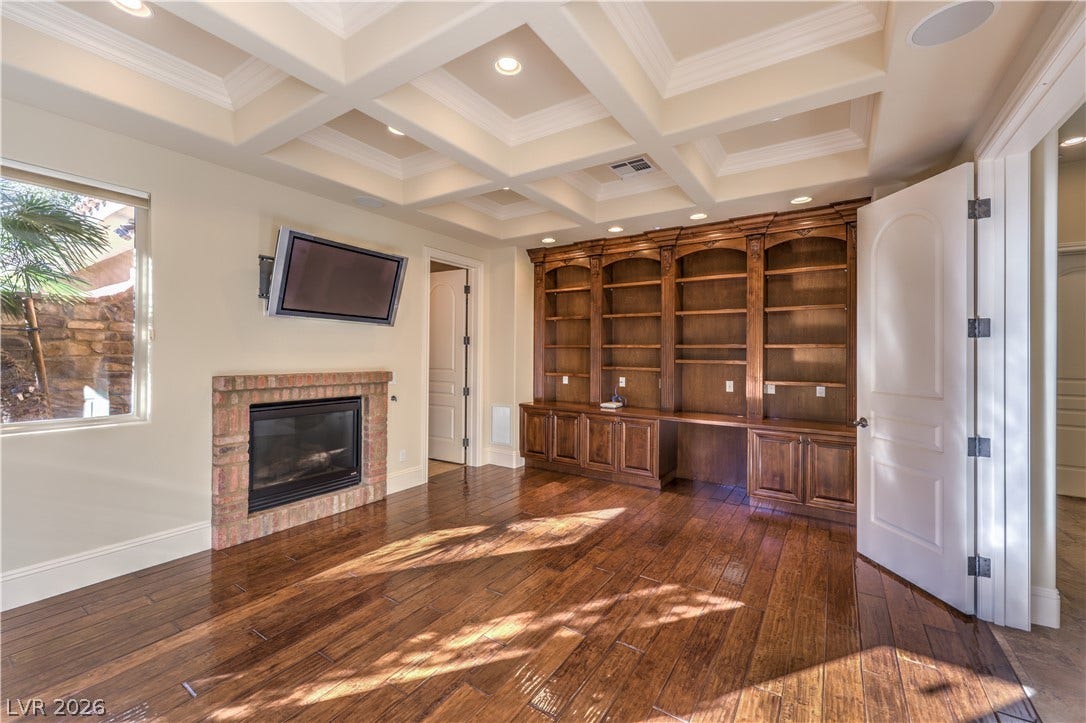 16 Anthem Pointe Court, Henderson, NV 89052 Rich hardwood floors complement the elegant coffered ceiling, cozy fireplace, and custom built-in bookshelves.