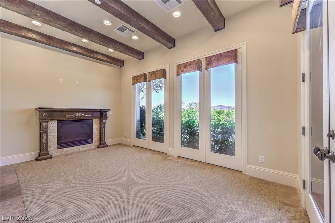 16 Anthem Pointe Court, Henderson, NV 89052 Rich wood beams and a classic fireplace anchor this serene space lined with French doors.