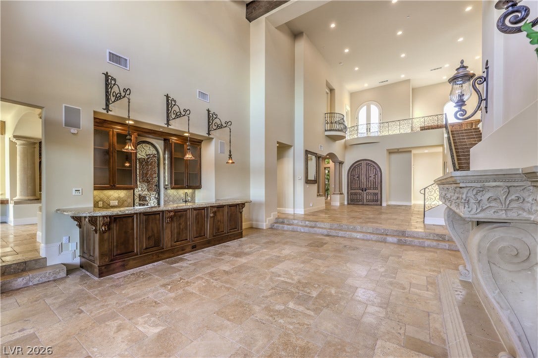 16 Anthem Pointe Court, Henderson, NV 89052 Grand arched entryways and a built-in wet bar define this magnificent stone-tiled great room.
