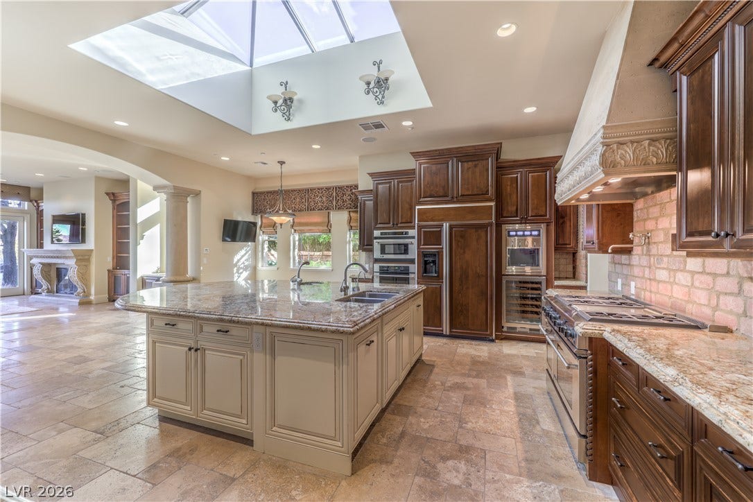 16 Anthem Pointe Court, Henderson, NV 89052 Natural light pours through a large skylight over the expansive kitchen island and stone flooring.