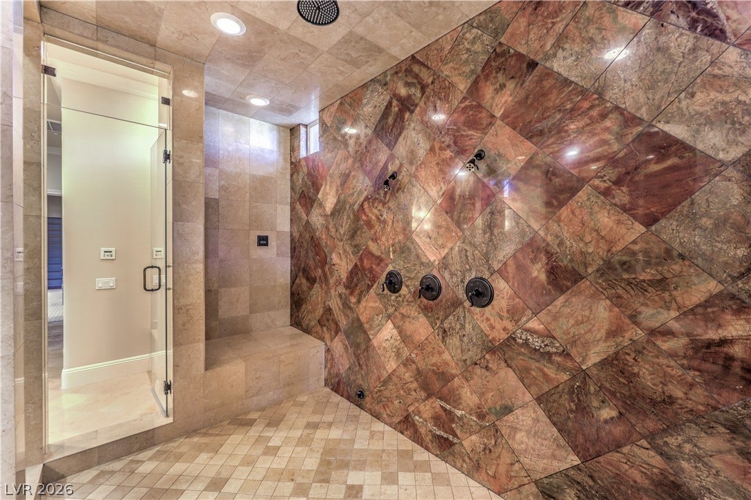 16 Anthem Pointe Court, Henderson, NV 89052 Richly patterned stone tiling and multiple shower heads define this luxurious walk-in shower.