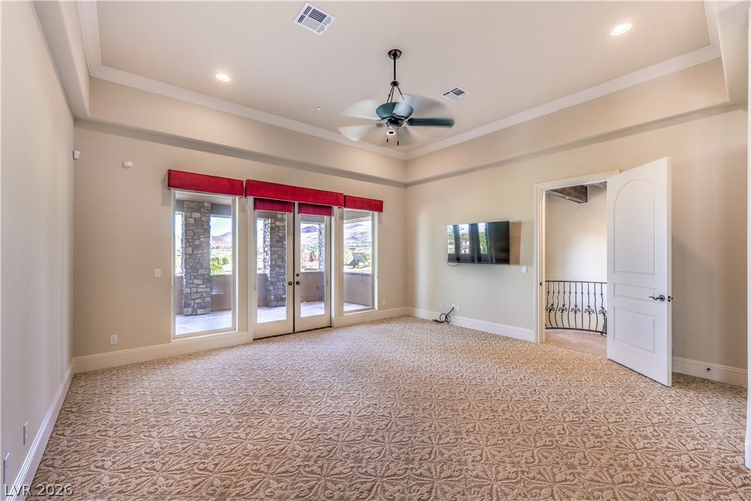 16 Anthem Pointe Court, Henderson, NV 89052 Double doors open to a private patio from this bedroom featuring detailed tray ceilings.