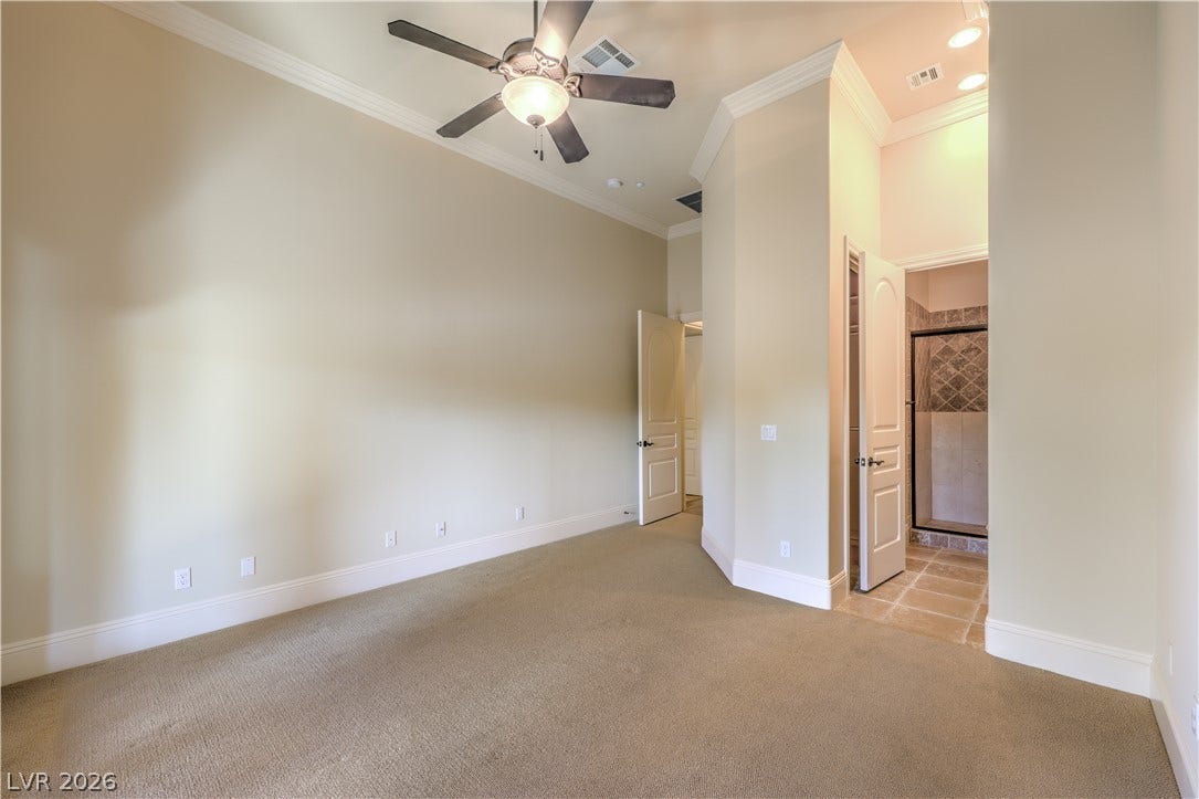 16 Anthem Pointe Court, Henderson, NV 89052 High ceilings and clean crown molding elevate this carpeted bedroom suite with an attached bath.