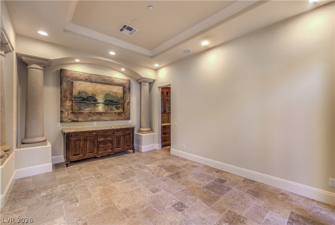 16 Anthem Pointe Court, Henderson, NV 89052 A spacious formal dining room showcases elegant crown molding, columns, and classic travertine tile flooring.