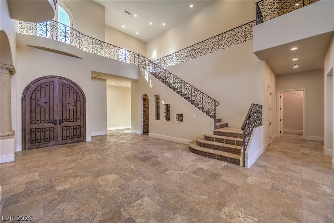 16 Anthem Pointe Court, Henderson, NV 89052 An arched double entry door opens to a grand foyer with a curved stone staircase.