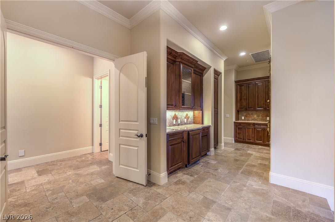 16 Anthem Pointe Court, Henderson, NV 89052 Gleaming tile floors and detailed crown molding elevate this functional hallway butler pantry area.