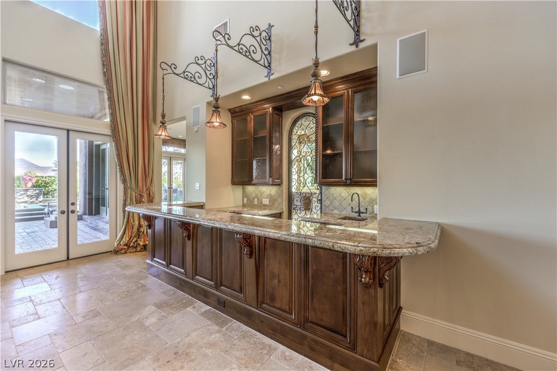 16 Anthem Pointe Court, Henderson, NV 89052 Richly detailed wooden cabinetry and granite countertops define this elegant built-in home bar area.