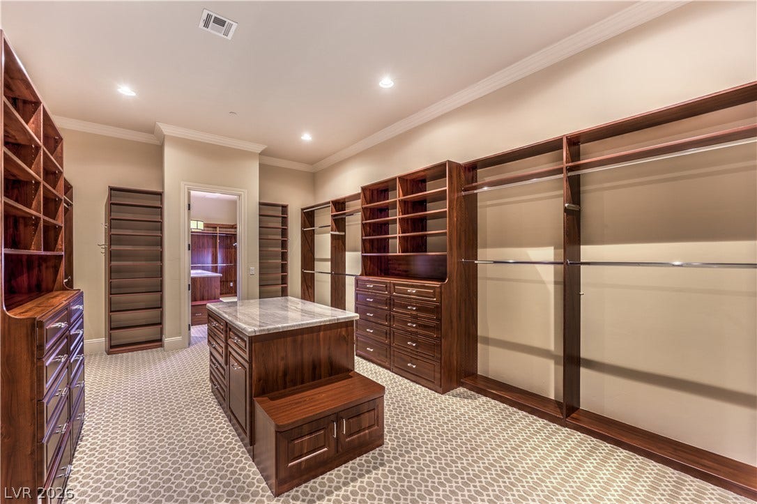 16 Anthem Pointe Court, Henderson, NV 89052 Custom wood shelving and a marble-topped island highlight this organized walk-in closet space.
