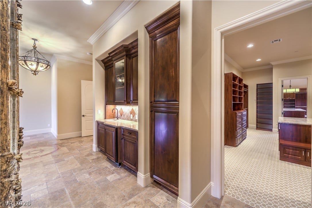 16 Anthem Pointe Court, Henderson, NV 89052 Gleaming tile floors and detailed crown molding connect the hallway bar to an expansive dressing suite.