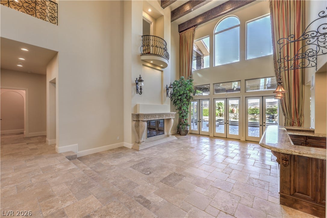 16 Anthem Pointe Court, Henderson, NV 89052 Soaring beamed ceilings and stone flooring frame a majestic fireplace in this open living space.