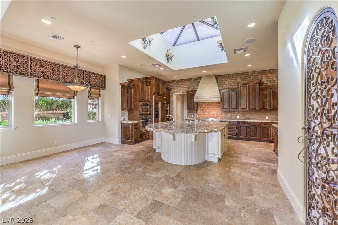 16 Anthem Pointe Court, Henderson, NV 89052 Natural light pours through a central skylight onto stone tile flooring and custom cabinetry.