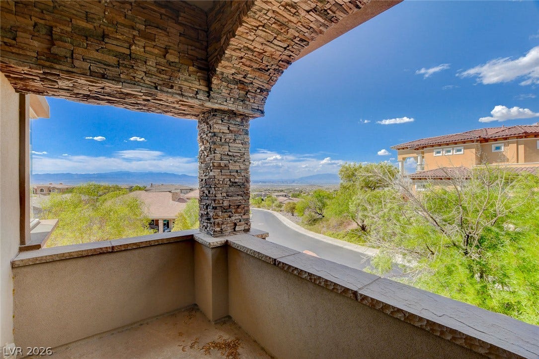84 Kittansett Loop, Henderson, NV 89052 An arched stone balcony looks out over the surrounding neighborhood and distant mountains.