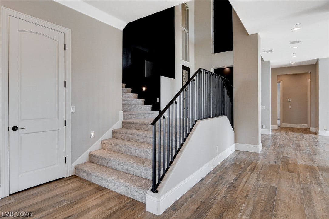 84 Kittansett Loop, Henderson, NV 89052 An elegant staircase features classic wood-look tile flooring and clean architectural lines.