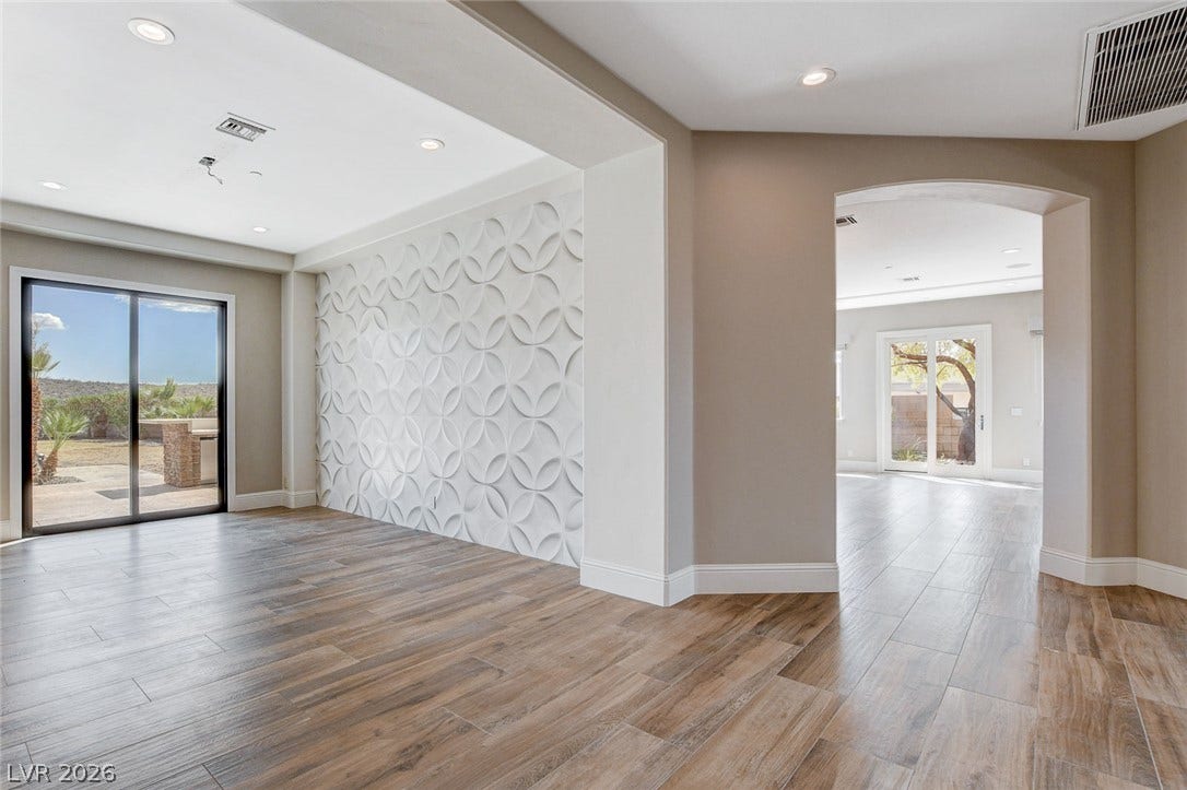 84 Kittansett Loop, Henderson, NV 89052 An open floorplan connects versatile living areas featuring textured wall details and durable tile flooring.