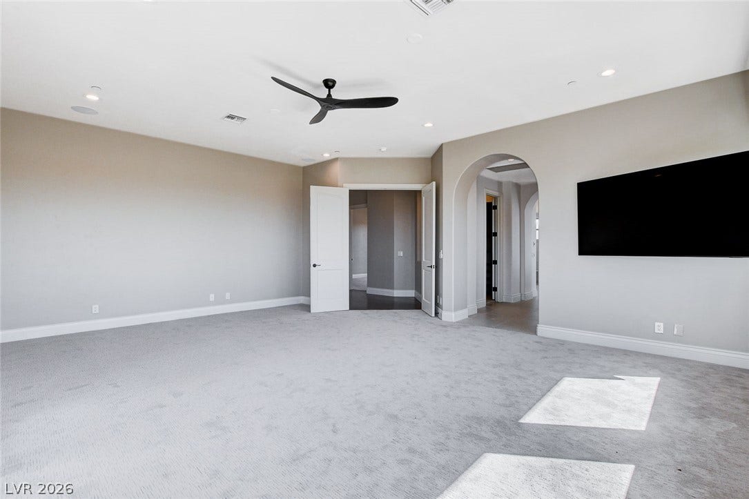 84 Kittansett Loop, Henderson, NV 89052 An arched doorway and plush carpeting highlight this flexible living space.