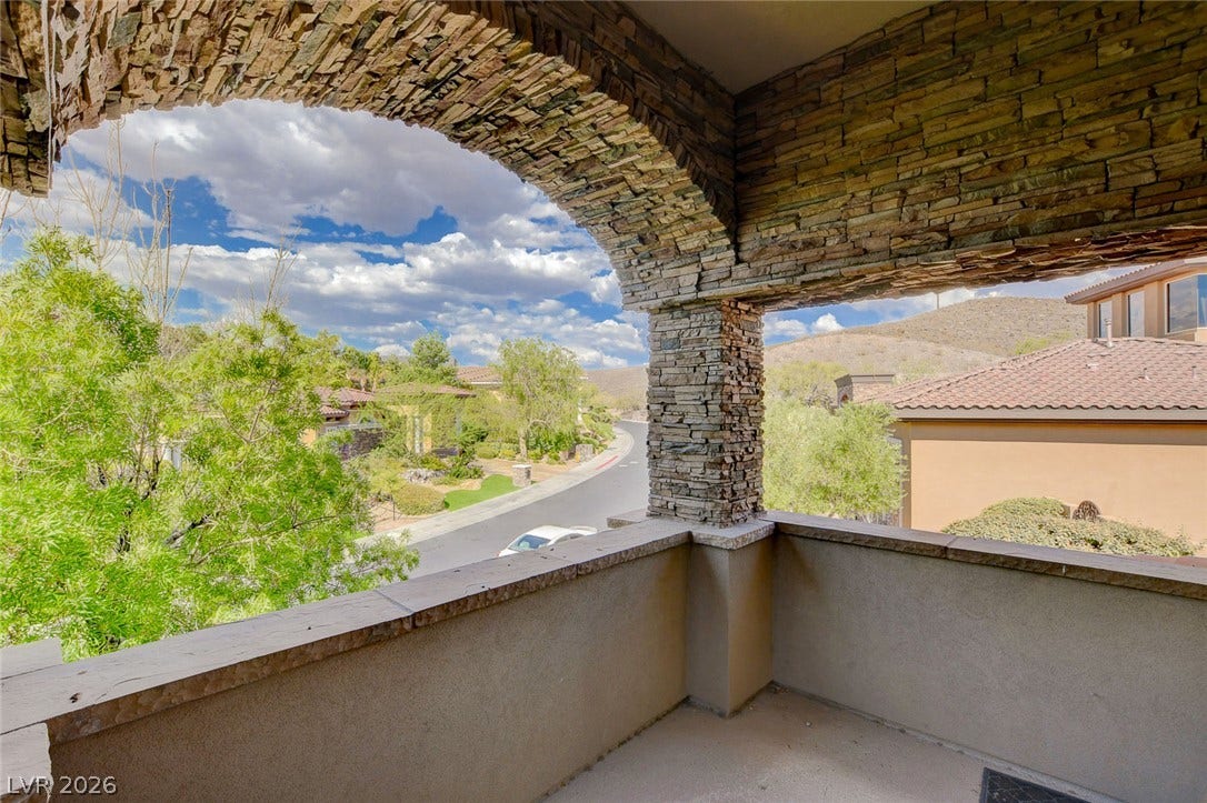 84 Kittansett Loop, Henderson, NV 89052 An arched stone balcony overlooks the surrounding neighborhood and rolling hills.
