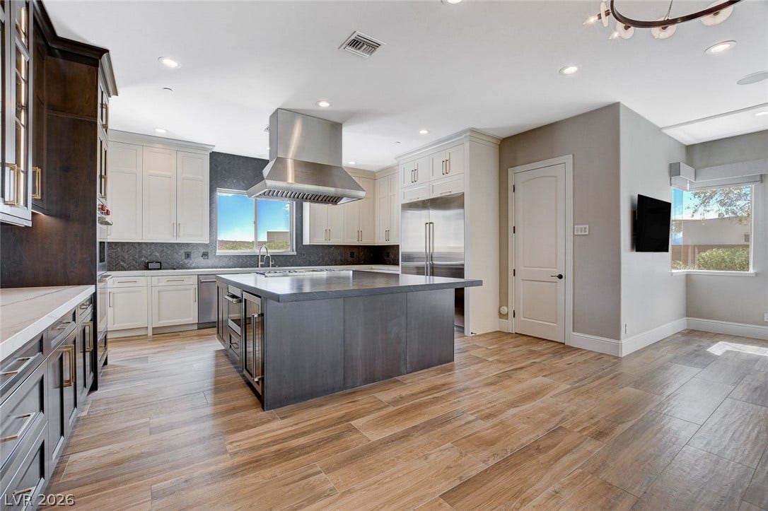 84 Kittansett Loop, Henderson, NV 89052 Rich wood floors and premium stone counters anchor this bright, open culinary space.