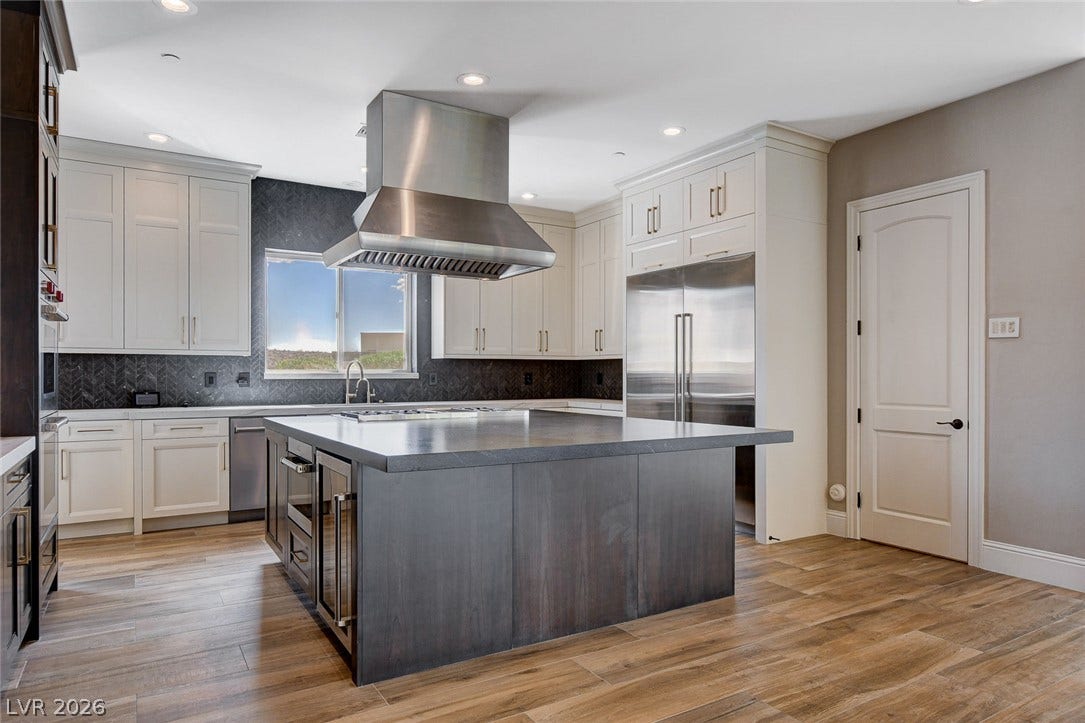 84 Kittansett Loop, Henderson, NV 89052 Rich wood floors complement custom cabinetry and a massive central island in this culinary space.