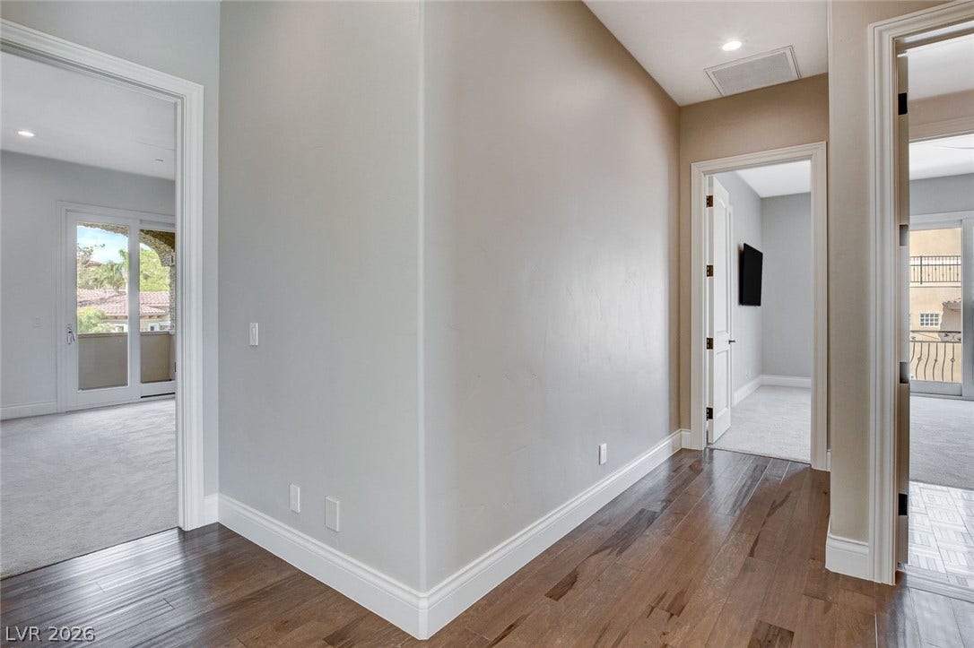 84 Kittansett Loop, Henderson, NV 89052 Rich hardwood flooring anchors the inviting hallway leading to carpeted bedrooms.