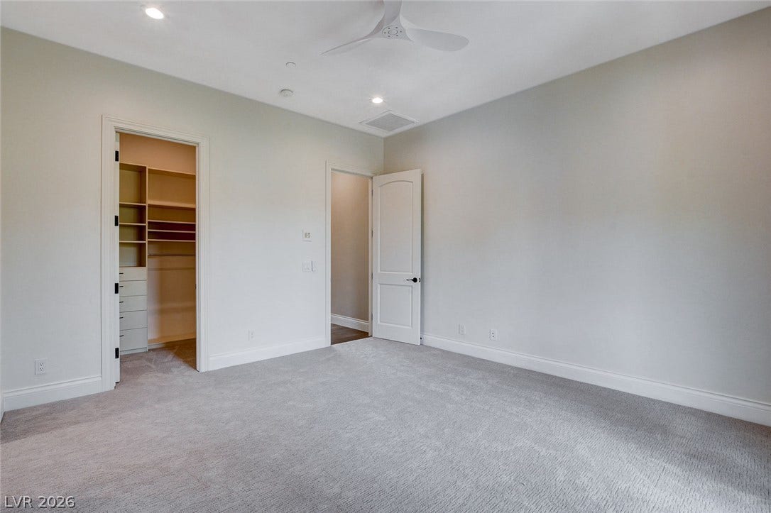 84 Kittansett Loop, Henderson, NV 89052 Plush carpeting anchors this spacious bedroom featuring a private walk-in closet with built-in organization.