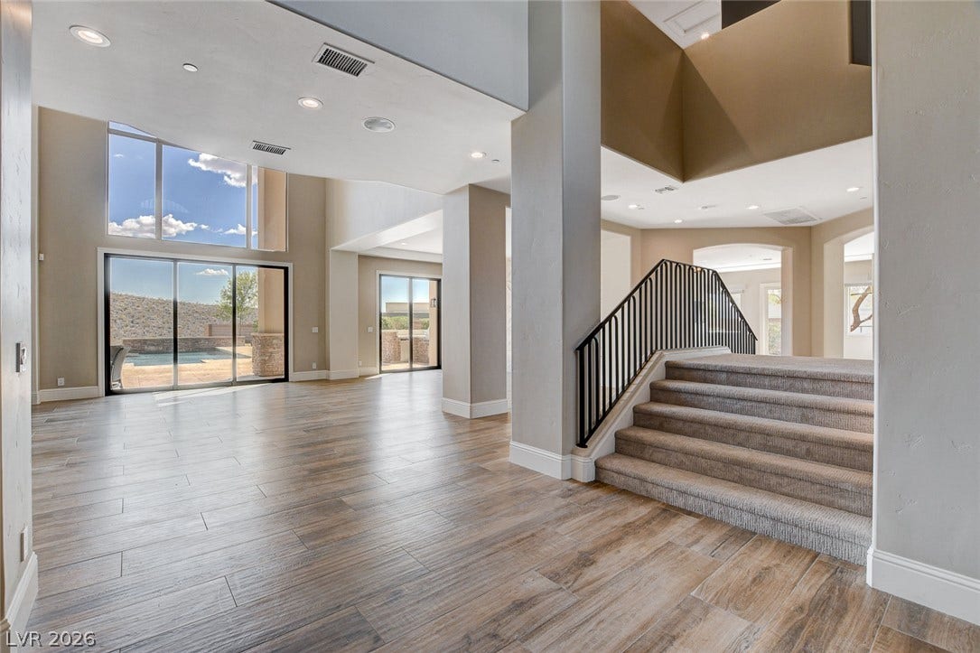 84 Kittansett Loop, Henderson, NV 89052 Towering ceilings and sliding glass doors frame views of the pool from this expansive entryway.