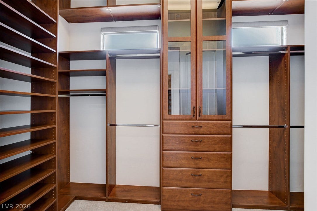 84 Kittansett Loop, Henderson, NV 89052 Custom wood cabinetry and built-in shelving define this organized walk-in closet space.