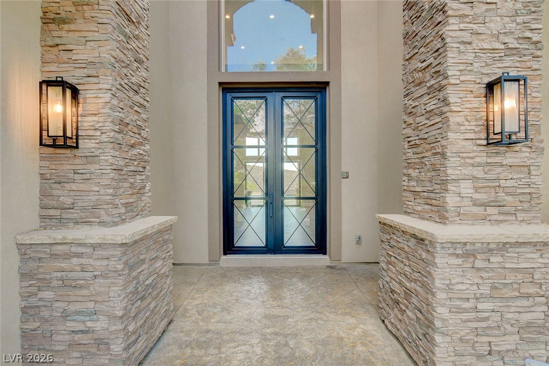 84 Kittansett Loop, Henderson, NV 89052 Framed by textured stone pillars, double glass entry doors open to this elegant residence.