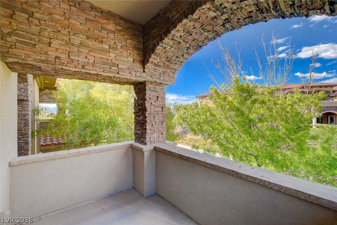 84 Kittansett Loop, Henderson, NV 89052 Stone archways frame leafy views from this elevated private balcony.