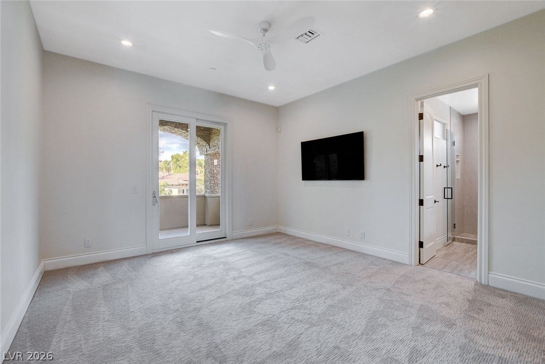 84 Kittansett Loop, Henderson, NV 89052 Glass sliding doors open to a private balcony from this carpeted bedroom suite.