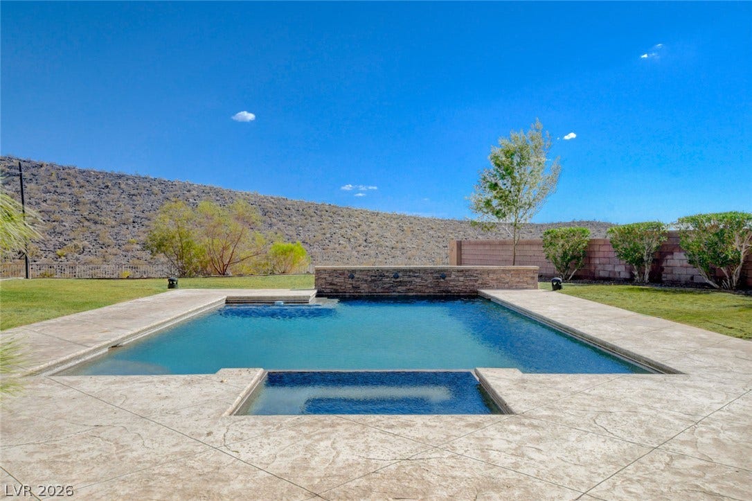84 Kittansett Loop, Henderson, NV 89052 An inviting backyard swimming pool and integrated spa overlook a scenic desert hillside.