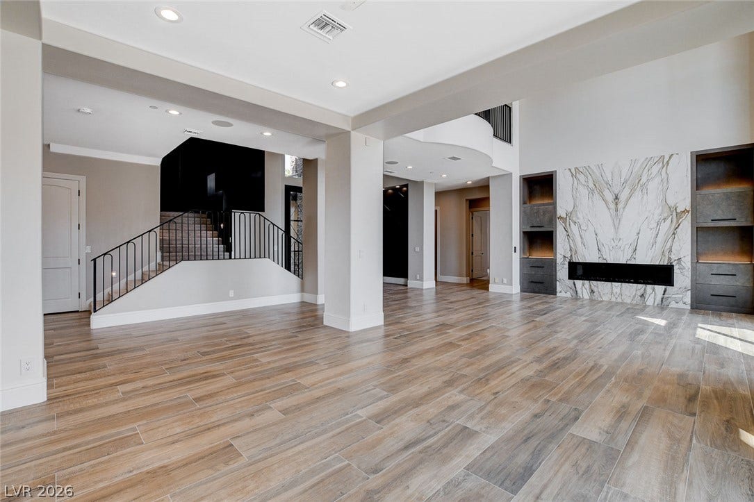 84 Kittansett Loop, Henderson, NV 89052 An open floorplan flows seamlessly past a modern marble fireplace and sleek tile flooring.