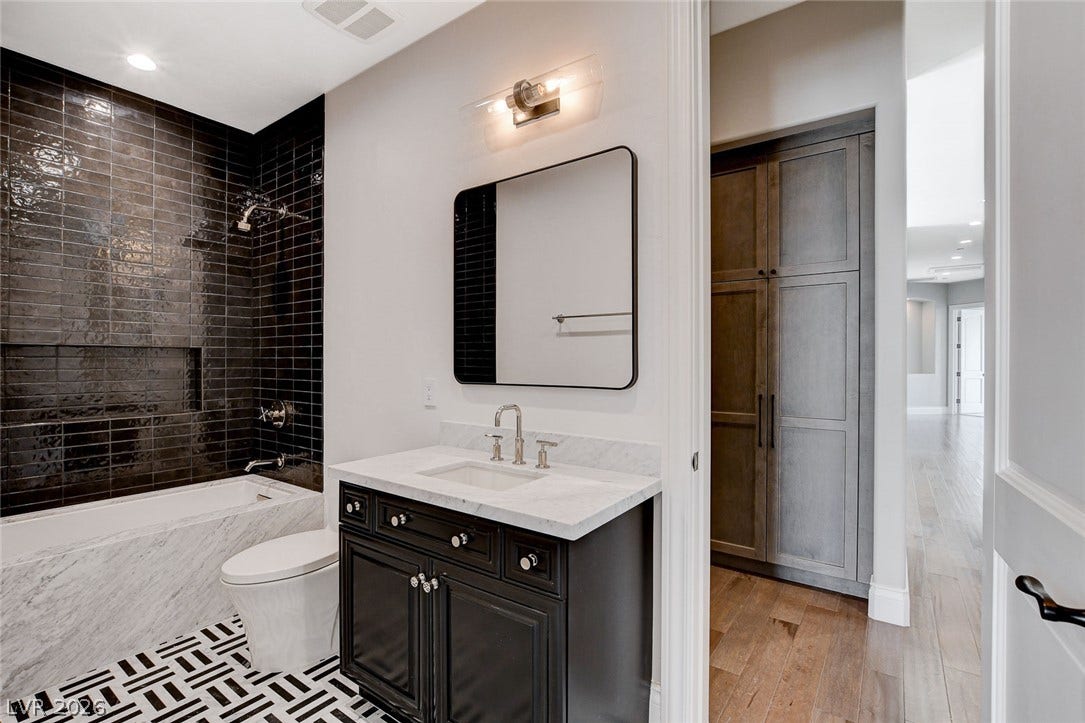 84 Kittansett Loop, Henderson, NV 89052 Bold tile finishes and built-in cabinetry elevate this contemporary bathroom space.