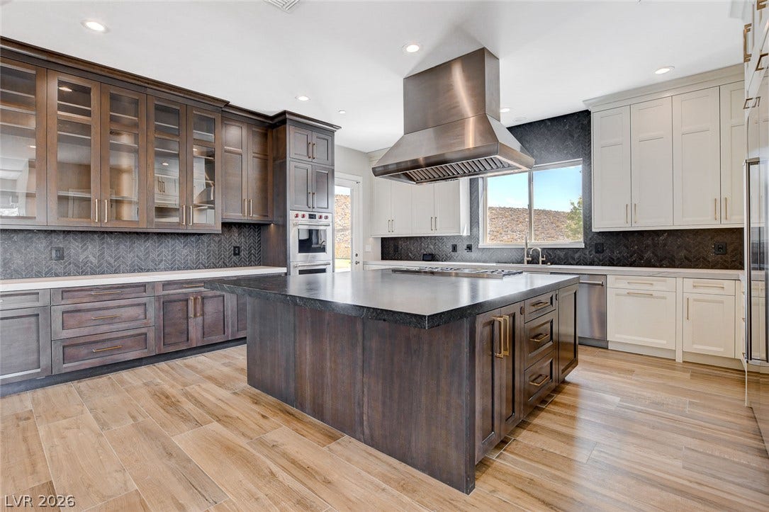 84 Kittansett Loop, Henderson, NV 89052 Rich wood cabinetry and a massive center island define this high-end culinary space.
