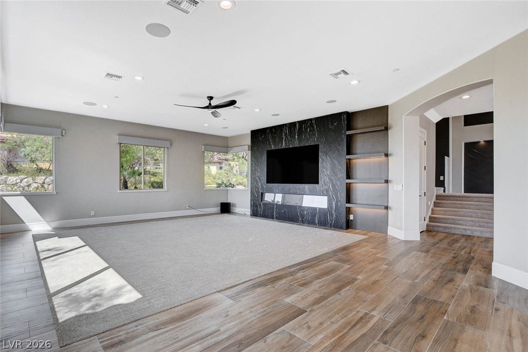 84 Kittansett Loop, Henderson, NV 89052 Gleaming wood-look tile floors and a sleek fireplace anchor this airy modern living room.