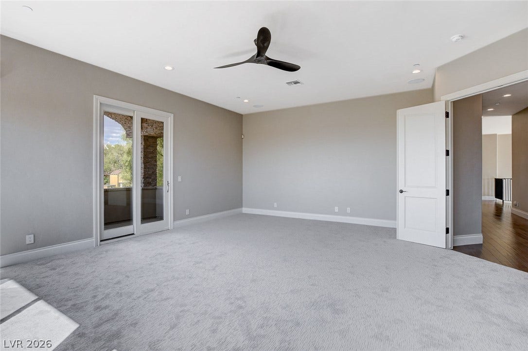 84 Kittansett Loop, Henderson, NV 89052 Sliding glass doors open to a private balcony from this spacious carpeted bedroom.