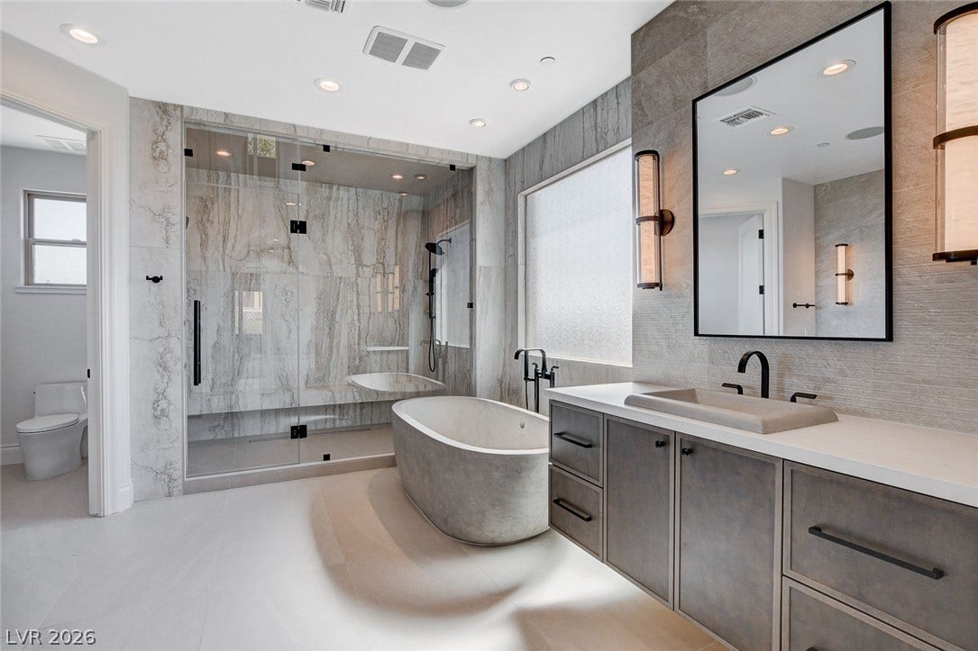 84 Kittansett Loop, Henderson, NV 89052 A freestanding tub and walk-in shower elevate this spa-like retreat.