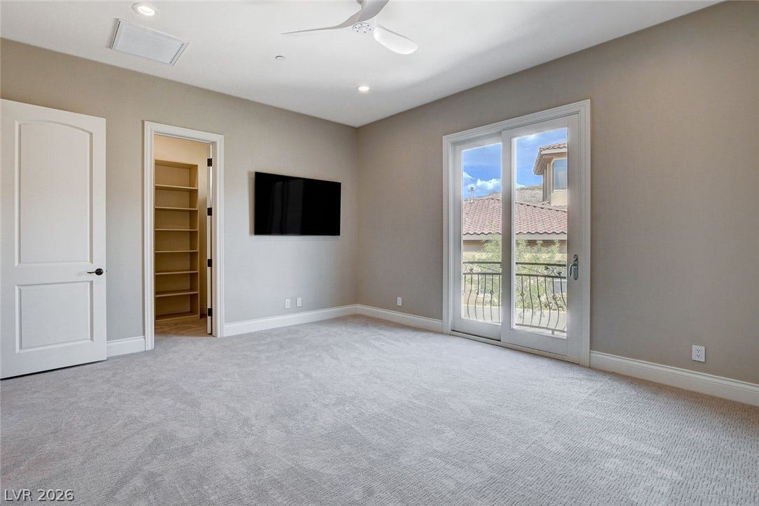 84 Kittansett Loop, Henderson, NV 89052 Sliding glass doors open to a private balcony in this carpeted upper-level room.