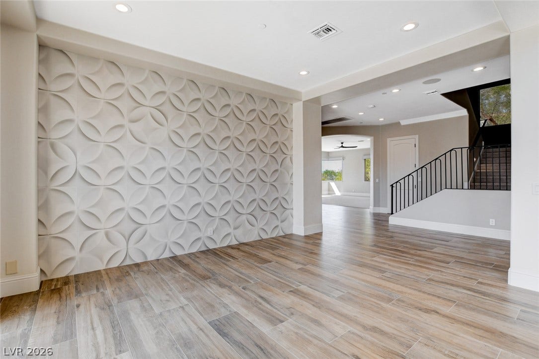 84 Kittansett Loop, Henderson, NV 89052 Gleaming wood-look tile floors and a textured feature wall define this airy transitional space.