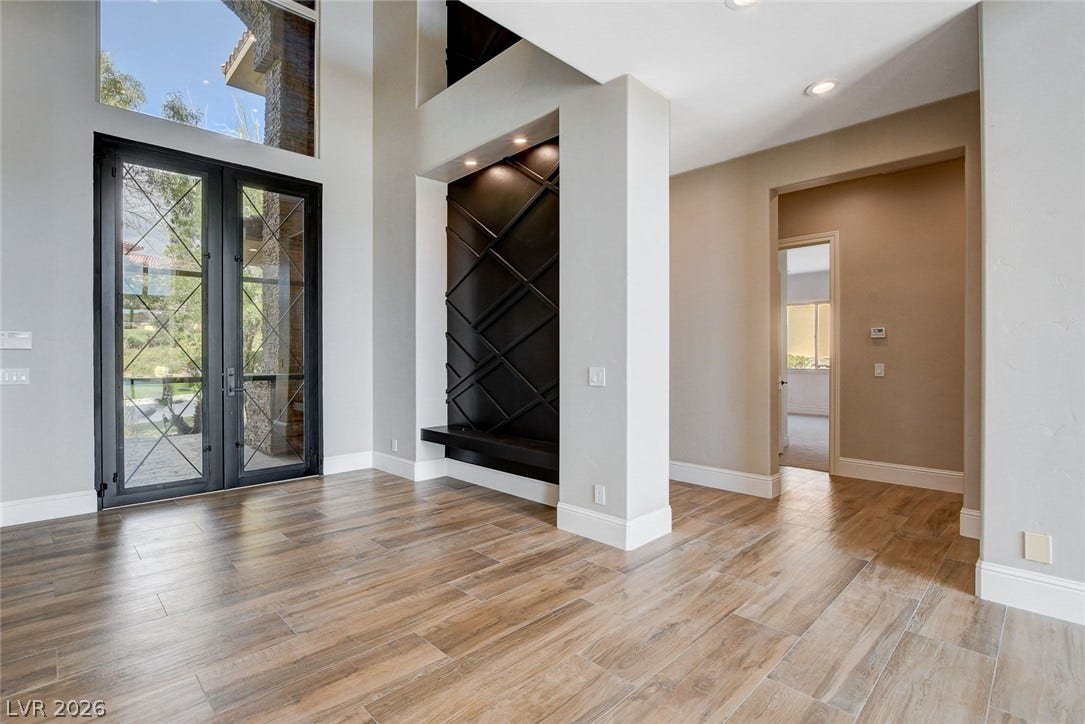 84 Kittansett Loop, Henderson, NV 89052 Grand scale defines this entrance featuring wood-look flooring and soaring multi-story ceilings.