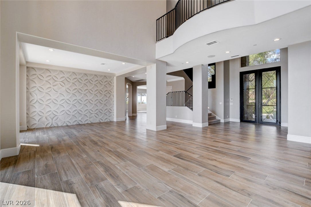 84 Kittansett Loop, Henderson, NV 89052 An open entryway showcases textured accent wall paneling, tile flooring, and a dramatic overlooking balcony.