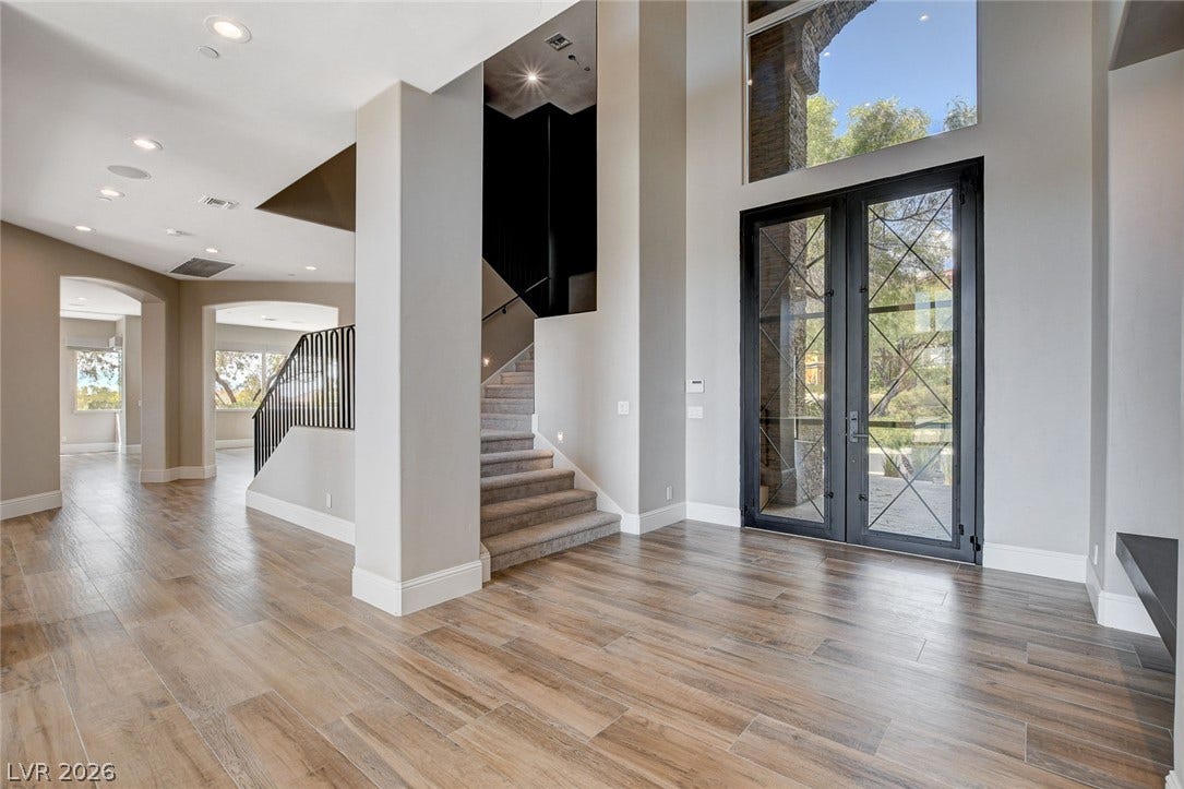 84 Kittansett Loop, Henderson, NV 89052 Towering ceilings and handsome wood-look flooring welcome guests into this light-filled entryway.